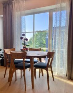 une table à manger avec des chaises et une grande fenêtre dans l'établissement Lux Studio HOTEL, à Keila