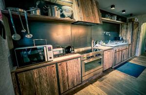 a kitchen with a microwave oven and a stove at La ferme du Comte in Durbuy