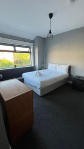 1 dormitorio con 2 camas y ventana en Twelve - Boutique Guest House -Galway City Centre -6 Bed En-Suite - Free Parking, en Galway