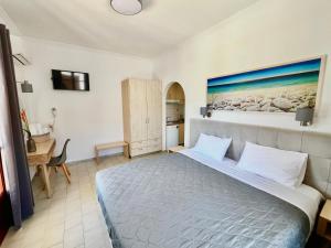 a bedroom with a large bed with a painting on the wall at ATHANASIA APARTMENTS in Skiathos