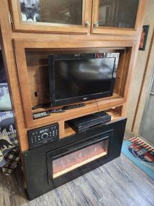a entertainment center with a television and a fireplace at Rv adventure Roscoe Pet friendly in Roscoe