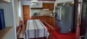 a kitchen with a table and a stainless steel refrigerator at Maison typique Basque en pleine campagne in Saint-Pée-sur-Nivelle
