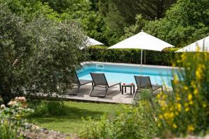 a pool with two chairs and a table with an umbrella at Borgo dei Fondi in Siena