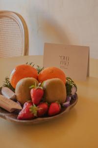 un bol de fruta en una mesa con un cartel en Omma, en Roussillon
