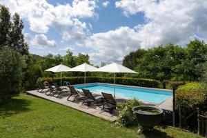 a swimming pool with chairs and umbrellas at Borgo dei Fondi in Siena