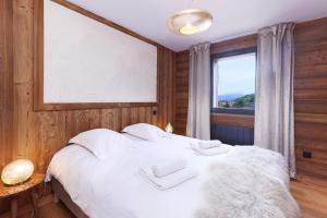 1 dormitorio con 1 cama blanca y ventana en Résidence l'Insolite, en Font-Romeu-Odeillo-Via