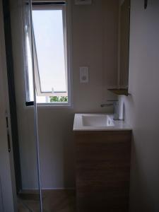 a bathroom with a sink and a window at Camping Le Damier in Pianottoli-Caldarello