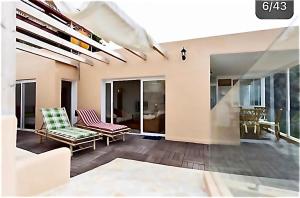 ein Wohnzimmer mit 2 Stühlen und Glasschiebetüren in der Unterkunft LOFT DOA with panoramic views and Wifi San Marcos in Icod de los Vinos