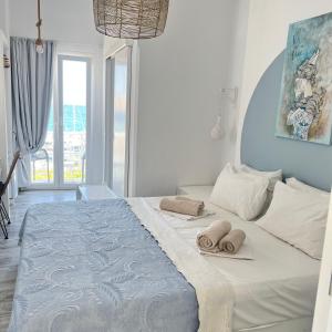 een slaapkamer met een bed met twee handdoeken erop bij Daphne in Naousa