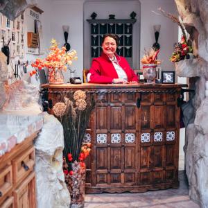 a woman standing behind a wooden counter in a store at Pension Haus Sanz in Vienna