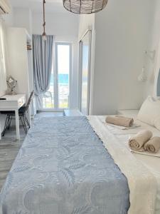 a bedroom with a large bed with a desk and window at Daphne in Naousa