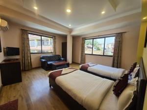 een hotelkamer met twee bedden en een bank bij Cascade Hotel in Kathmandu