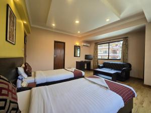 een hotelkamer met twee bedden en een bank bij Cascade Hotel in Kathmandu