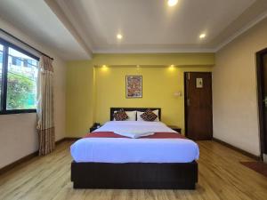 een slaapkamer met een groot bed in een kamer bij Cascade Hotel in Kathmandu