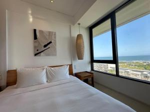 um quarto com uma cama branca e uma grande janela em Villa seaview and apartment Da Nang Resort by JT group "Free pick up" em Da Nang