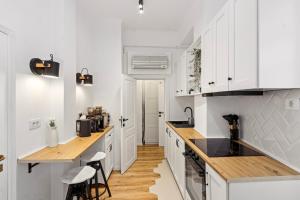 a kitchen with white cabinets and wooden counter tops at SkyCentral Bucharest in Bucharest
