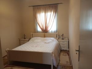 a bedroom with a white bed and a window at Αρχοντικο in Ayía Sofía
