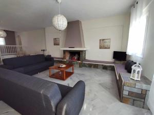 a living room with a couch and a fireplace at Beachfront Villa Gia Paros in Kampos Paros