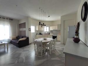 a kitchen and living room with a table and a couch at Beachfront Villa Gia Paros in Kampos Paros