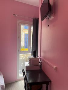 une chambre avec une table, un four micro-ondes et une fenêtre dans l'établissement Résidences saint pierre, à Lourdes