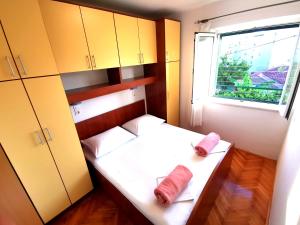 Habitación pequeña con cama y ventana en Apartmani Rudelj, en Makarska