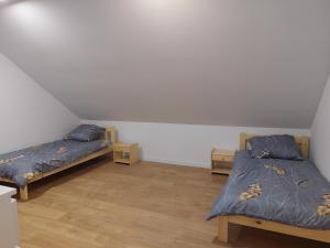 um quarto com 2 camas e piso em madeira em Pokoje Kraków Tyniec na Cracóvia