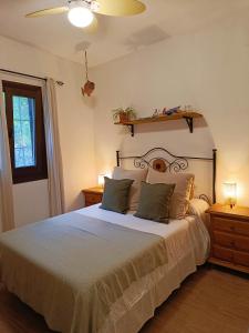 um quarto com uma grande cama branca com duas mesas de cabeceira em La Encina em Lanjarón