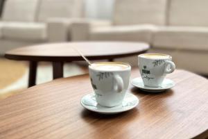 two cups of coffee sitting on a wooden table at Hotel Don Ignacio in San José