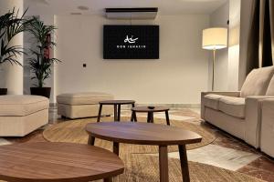 a living room with two tables and a couch at Hotel Don Ignacio in San José