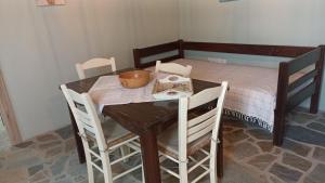 a wooden table with chairs and a table with a bowl on it at Anna’s Olive Grove in Ammouliani