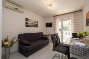 a living room with a couch and a table at Apartments Šerbečić in Malinska