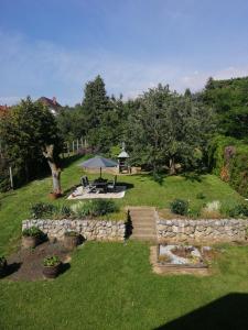 a garden with a picnic table and a stone wall at Betti Vendégház in Alsópáhok