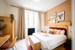 a bedroom with a large white bed and a window at Villa Vichéia - Appartement 14 - UNESCO - Centre-Ville in Vichy