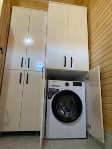 lavadora en una habitación con armarios blancos en Plaj Hotel, en Cıralı