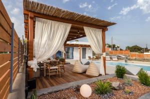 a deck with a table and chairs next to a pool at Osmio Luxury Residence in Adamantas