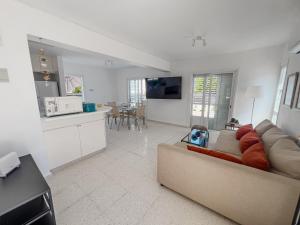 a living room with a couch and a kitchen at Protaras Sunny Villa in Protaras