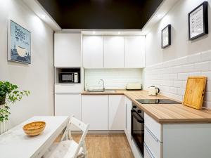 a kitchen with white cabinets and a wooden counter top at Laura apartment in Budapest