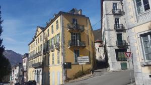 un edificio amarillo al lado de una calle en Vaste appartement, lumineux, 8 couchages, en Eaux-Bonnes