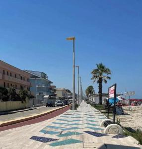 a street with cars parked on the side of a beach at Sole e mare in Porto SantʼElpidio