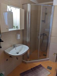 a bathroom with a sink and a shower at Apartments Monika in Novi Vinodolski