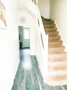 un corridoio con pareti bianche e scale con pavimenti in legno di 3 Bedrooms, Families, Contractors, Wi-Fi, Parking, Sleeps 7 - CLARK PROPERTY ESTATES a Southend-on-Sea Altre 16 foto