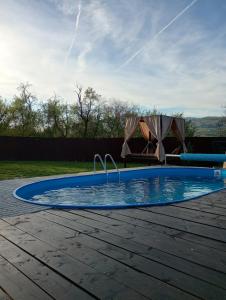 a small swimming pool with a table in a yard at Casa Calina in Călimăneşti