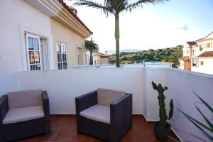 2 sillas en un balcón con una palmera en Tarifa Family House 5 min walk to the beach and old town, en Tarifa