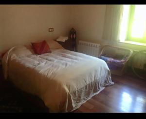 Un dormitorio con una gran cama blanca en una habitación. en Basoan etxea, en Sopuerta