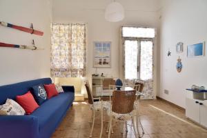 Una sala de estar con un sofá azul y una mesa. en Terrazza sul Corso, en Pozzallo