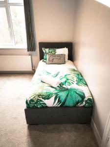 a small bedroom with a bed with a green bedspread at CLARK PROPERTY ESTATES - Southend - 3 Bedrooms - 5 Beds - Garden - Business & Leisure - Long or Short Term Enquire Today! - Sleeps 8 inc sofa beds! in Southend-on-Sea