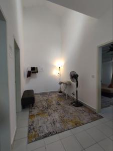 a room with a rug on a white wall with a lamp at Homestay Banting Selangor in Banting