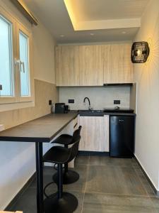uma cozinha com armários de madeira e uma mesa e cadeiras em Casa di Angela em Míconos