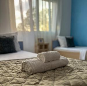 2 asciugamani posti sopra un letto di LefCoast AURA Apartments a Tragasiá