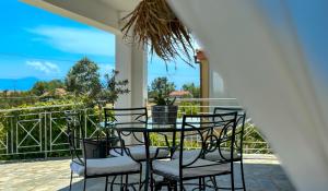 un patio con tavolo e sedie sul balcone. di LefCoast AURA Apartments a Tragasiá